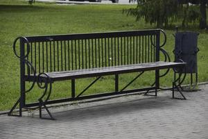 A large wooden bench in the city park in summer photo