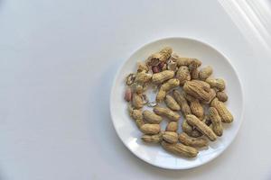 Nuts peanuts in a shell on a white plate photo