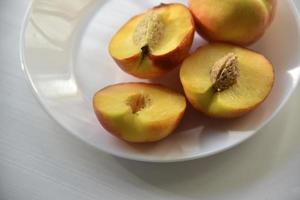 Sliced peaches and nectarines on a white plate photo