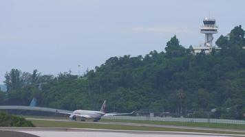 phuket, thailand 28 november 2019 - vliegtuig van qatar airways start op de luchthaven van phuket. uitzicht vanaf de bovenste verdieping van het hotel in de buurt van de luchthaven. toerisme en reisconcept, luchtvlucht video