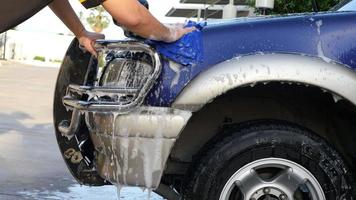 El hombre lava el coche con champú - concepto de cuidado del coche de la vida cotidiana video