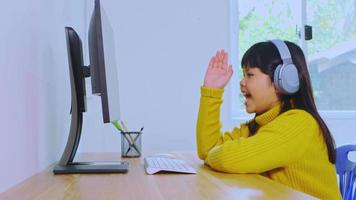 asiatische Mädchen lernen online und sehen sich das Tablet zu Hause an