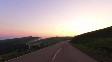 oogpunt auto rijden in Georgië Kaukasus serpentine weg buitenshuis op schilderachtige zonsondergang met mist en bergen panorama