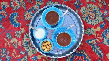 Yazd, Iran, 2022 - Persian coffee set up for two on beautiful decorated silver plate, blue cups and bowl of candies and sugar video
