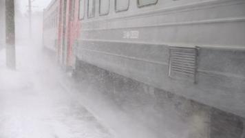 novosibirsk region, ryska federationen 5 januari 2017 - förortståg anländer till stationen, snöstorm, slow motion video