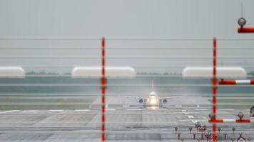 aereo di linea passeggeri che decelera dopo l'atterraggio sotto la pioggia. aeroporto di dusseldorf, germania video