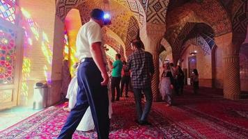 Shiraz, Iran, 2022 - Nasir Al-mulk crowded mosque interior time lapse with tourist walk explore and take photo of beautiful interior details video