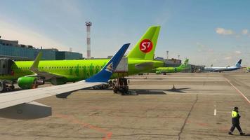 NOVOSIBIRSK, RUSSIA APRIL 14, 2018 - Airplanes on apron Tolmachevo International airport, view from towing airplane video