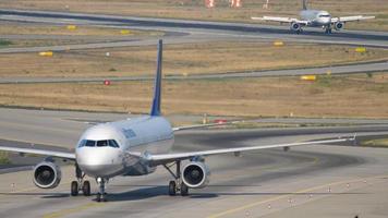 frankfurt am main, duitsland 19 juli 2017 - lufthansa airbus 321 taxiën na de landing op 07l en een andere lufthansa airbus a320 remmen op de startbaan op de achtergrond. fraport, frankfurt, duitsland video