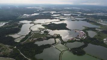 Aerial view reflection at abandoned tin mining lake and plantation video