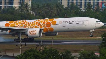 phuket, thailand 3 december 2018 - emiraten Boeing 777 met expo 2020-kleuren aflopend voor landing op phuket airport -hkt-. enorme straalvliegtuig aankomst video