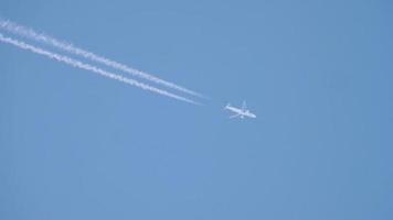 scie di condensazione nel cielo azzurro di agosto. aereo che vola alto. video