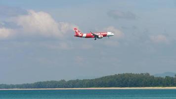 phuket, thailand 27 november 2019 - airasia airbus a320 flygplan på sista inflygning över mai khao beach, innan landning på phuket internationella flygplats i slow motion. video