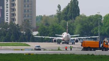 almaty, cazaquistão, 5 de maio de 2019 - voe o avião arystan airbus a320 sendo rebocado para o terminal para carregamento antes da partida do aeroporto internacional de almaty, cazaquistão. video