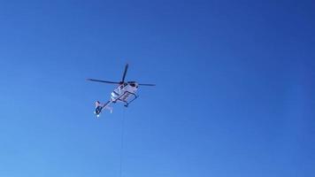 hélicoptère de sauvetage atterrissant sur les pistes aidant le skieur dans un parc à skis. ambulance aérienne dans les alpes. transport de secours. video