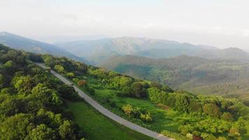 Aerial birds eye view of Two cars driving on asphalt road in scenic caucasian mountains. Travel in Georgia video