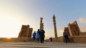 ruines pittoresques sur fond de ciel bleu avec touriste à persépolis, iran. ancienne ville perse. persepolis destination touristique populaire au moyen-orient.