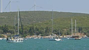 bateaux de plaisance en mer et éolienne électrique en montagne video