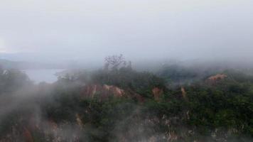 toppen av röd jord kulle i dimmigt moln dag video