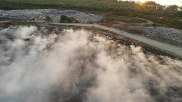 Aerial view fly forward garbage dump site release smoke video