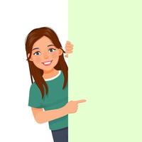 beautiful young woman peeking from behind blank billboard pointing index finger to empty banner for copyspace advertising and announcement messages vector