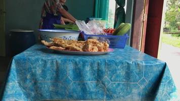 la actividad matutina del vendedor de tempeh frito en una tienda sencilla video