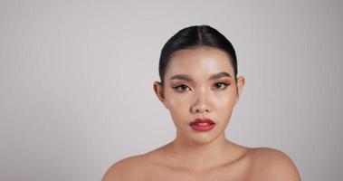 close-up de rosto de mulher asiática atraente olhando para camera.beautiful modelo feminino com pele fresca limpa perfeita. tratamento de cuidados com a pele ou conceito de anúncios cosméticos. video