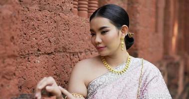 portret van thaise vrouw in klederdracht die naar de camera kijkt en lacht in de oude tempel. video