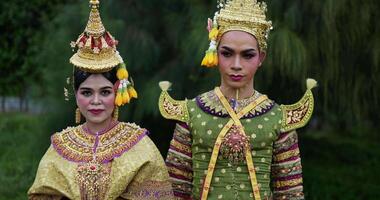 porträt einer thailändischen frau und eines mannes in traditioneller kleidung, die die kamera betrachten. thailändische kultur und thailändisches tanzkonzept. video