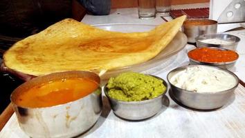 Paper Masala dosa is a South Indian meal served with sambhar and variety of coconut chutney . Selective focus photo
