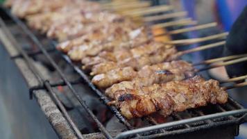 Grilling crocodile meat in street food at Thailand. Meat exotic skewers barbecue in asian street food video
