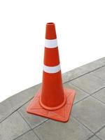 Traffic cone on the sidewalk isolated on white background photo