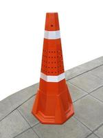 Traffic cone on the sidewalk isolated on white background photo