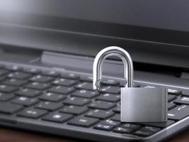 Computer security concept. Unlocked padlock on laptop keyboard. Symbol of safe. Toned soft focus picture photo