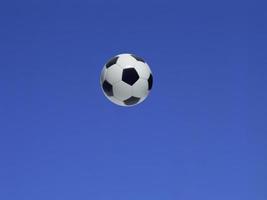 A soccer ball shot in the air with blue sky background photo