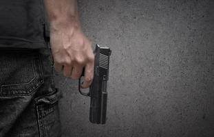 Killer with gun close up over grunge background with copyspace photo