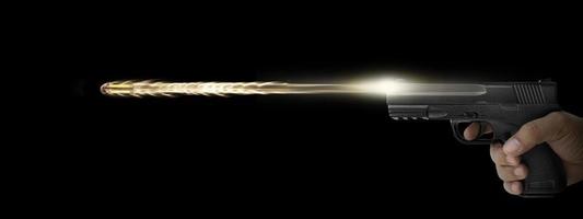 The hand presses the trigger of the gun and the flame from the shot escapes from its muzzle photo