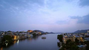 Abendansicht der Skyline der Stadt Udaipur und des Pichola-Sees im Zeitraffer video