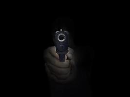 Close up male hand showing gesture try to kill someone with gun, Gunman with dark background photo