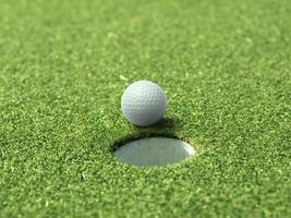 pelota de golf en el borde de la copa de un hermoso y hermoso campo de golf foto