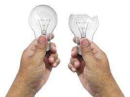 The broken bulb in a hand  Isolated on white background photo