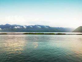 Beautiful natural scenery of river in southeast Asia tropical green forest with mountains in background photo