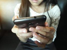 Close-up of kid's hands close up holding digital Smart phone for playing and education photo