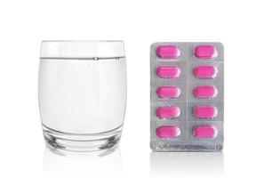 paquete de pastillas y un vaso de agua. concepto de farmacia y medicina foto