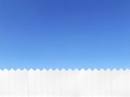 valla de madera blanca y sobre un fondo de cielo azul claro foto