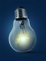 A man's hand holding an Light bulb open, isolated, on blue background photo