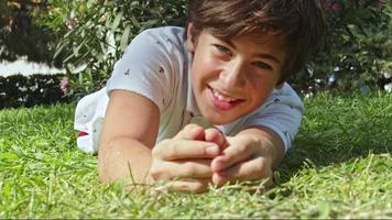 menino adolescente rolando na grama