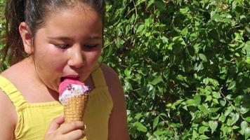 niña sonriendo mirando a la cámara mientras come helado video