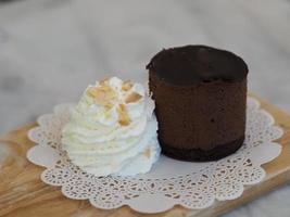 Chocolate Cake piece with Whipped Cream on white paper wooden tray photo