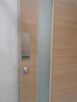 Push type door handle, black text latch in the stainless steel plate and keyhole on wooden door photo